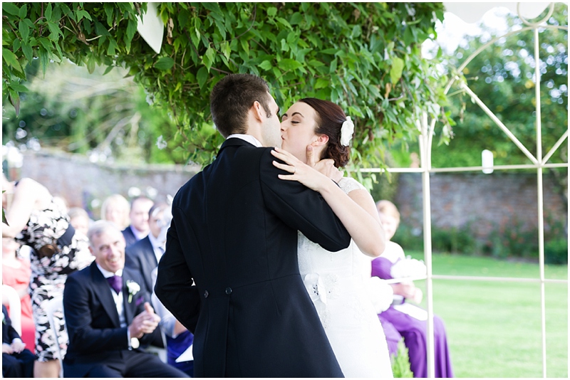 bride and groom kiss outdoor ceremony