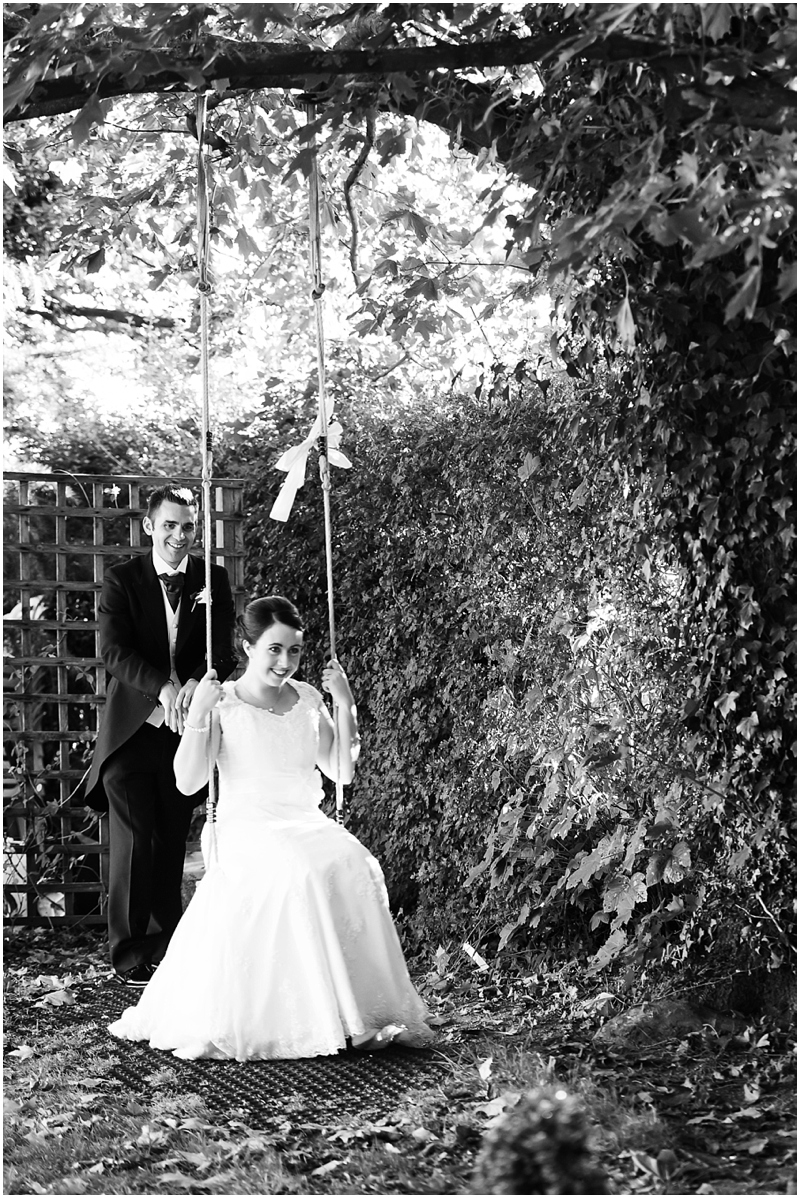 bride and groom on swing at wedding