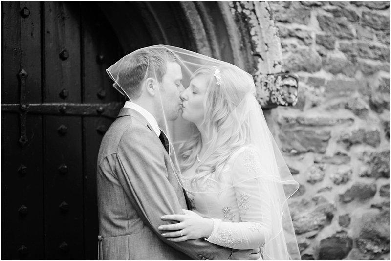 bride and groom kiss under veil