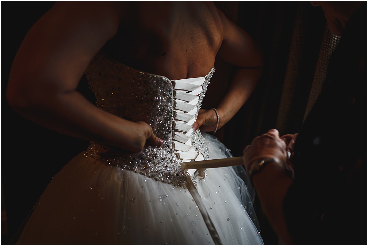 bride getting onto dress