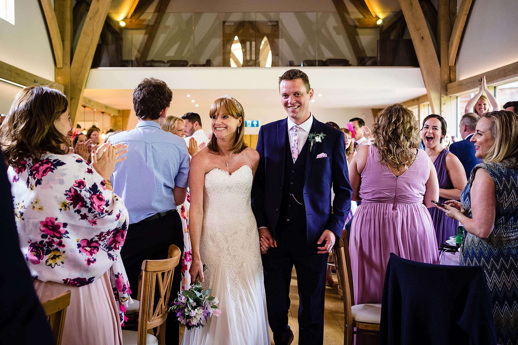 bride and groom enter wedding breakfast room