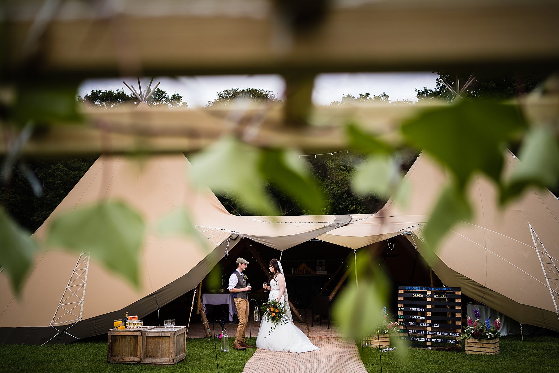 bride and groom standing outside tipi